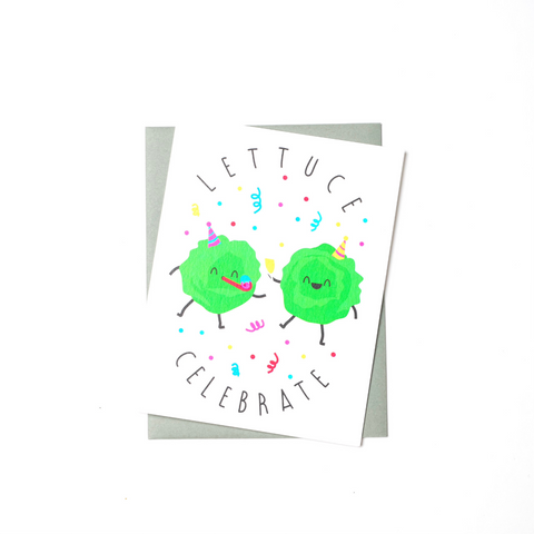 congratulations card with an illustration of two heads of lettuce celebrating wearing party hats.  One lettuce has a noisemaker in its mouth and the other is holding a glass of champagne.  They are  both surrounded by confetti.